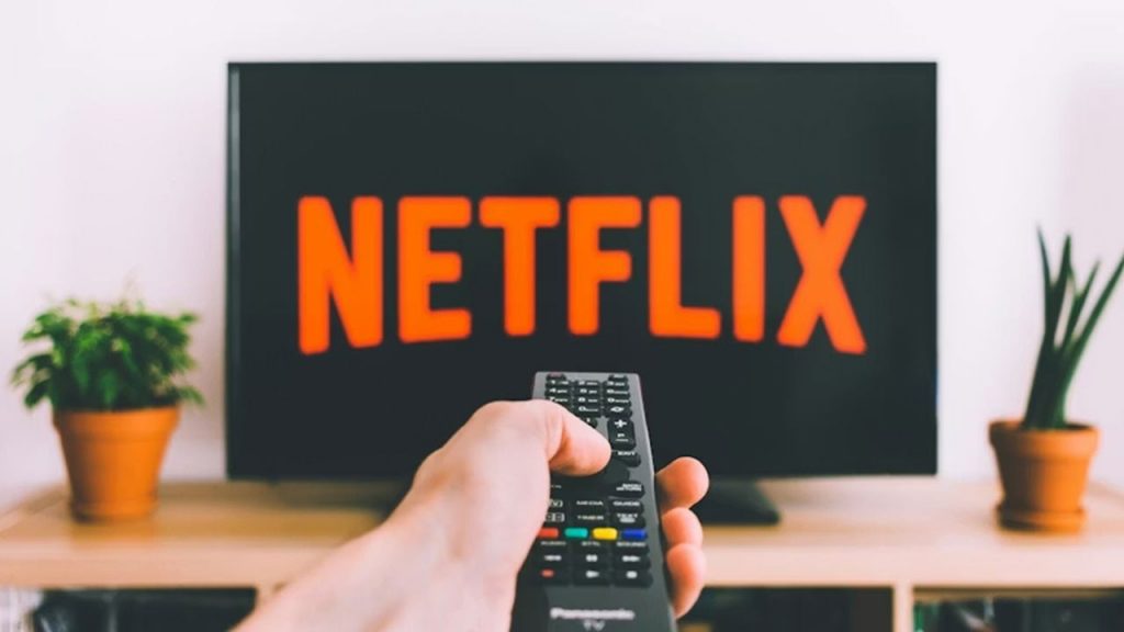 Everything You Need to Know About Netflix’s Live Vote Feature Person pointing remote at TV with Netflix on screen.