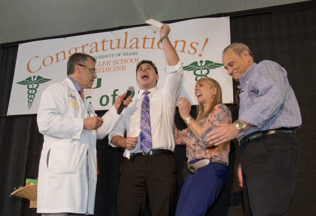 Matthew Stark, center, celebrates with his mother Barbara, second from right, father Steven, right, of Boca Raton, Fla., and Pascal J. Goldschmidt, left, dean for the University of Miami Miller School of Medicine, after learning which residency training program he was matched with, Friday, March 18, 2016, in Miami. Stark was one of 186 medical students at the school that learned where their studies would lead them next during Match Day, a day considered to be the crucial first step to practicing medicine, is an event held simultaneously at every medical school in the U.S. (AP Photo/Wilfredo Lee)
