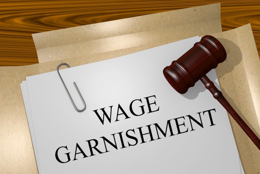 A folder and gavel with paperwork that says "Wage Garnishment". Source: The College Investor