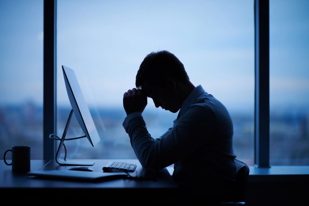 NY Fed: 3.6 Million Federal Student Loan Borrowers Have Defaulted Since October Tired or stressed man at computer due to defaulted student loan debt. Source: The College Investor