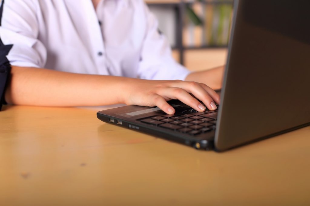 Students Pick Work Over College As AI Rewrites Career Plans A young girl sits at a computer deciding on college applications and majors in the face of AI.