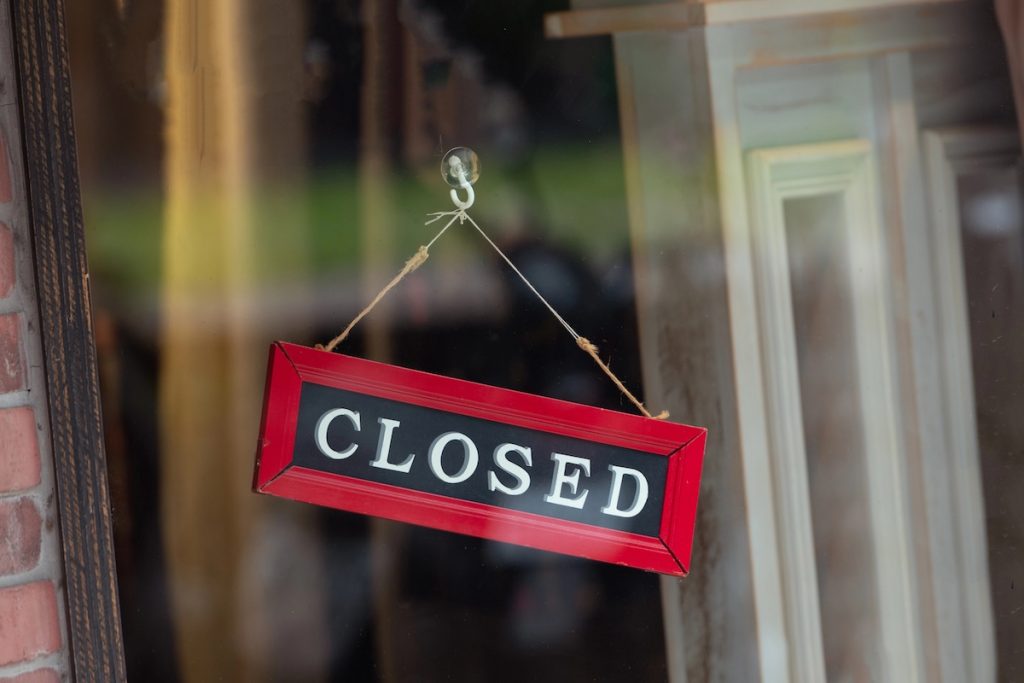 Could Your College Close? 5 Warning Signs Every Family Should Watch For sorry we are closed sign hanging outside, representing colleges as risk of closure.
