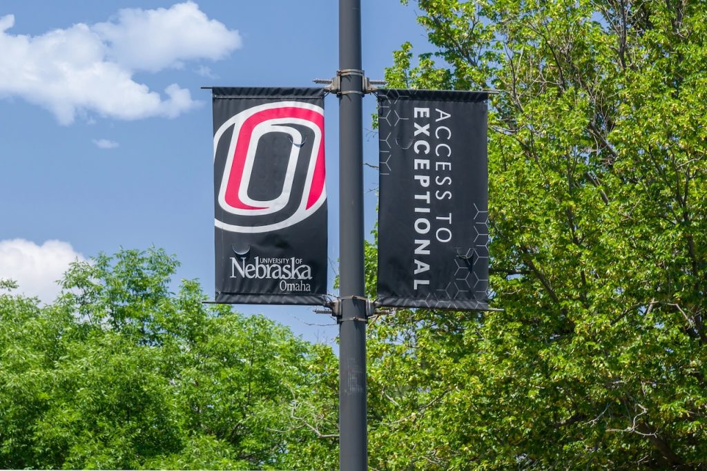 Gov. Pillen Orders $36 Million Mid-Year Cut To University Of Nebraska OMAHA, NE, USA - College flag on the campus of the University of Nebraska Omaha.